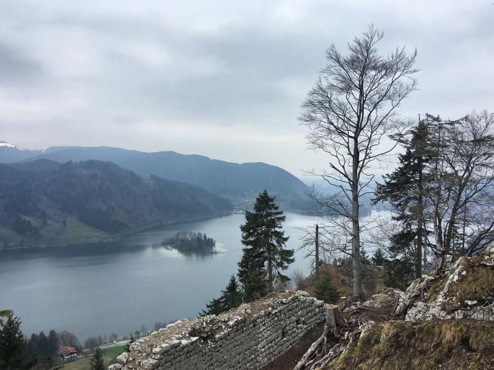 Free Image of Serene lake view with island and surrounding mountains. 