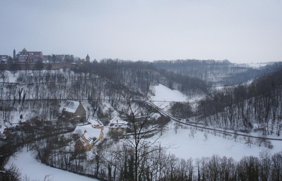 Free Image of Snow-covered landscape with houses and hills in winter 