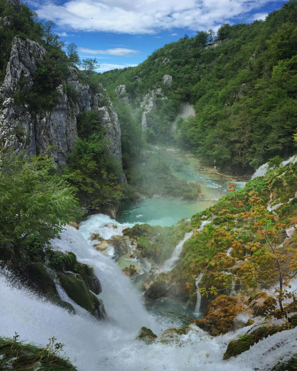 Free Image of Rushing waterfalls cascading through a verdant canyon 