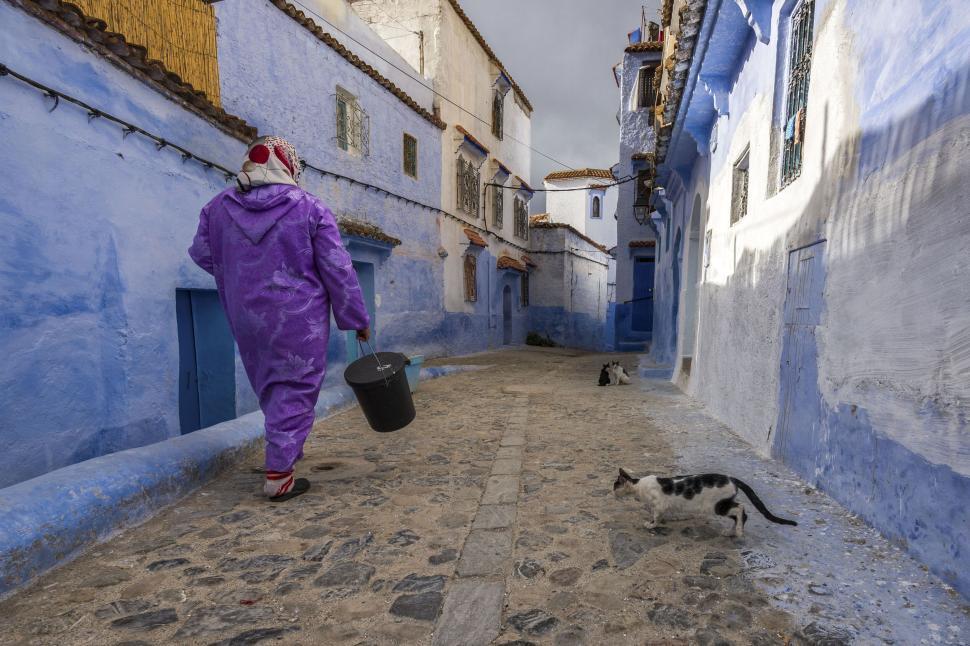 Free Image of Street view in a blue-painted town with a local resident 