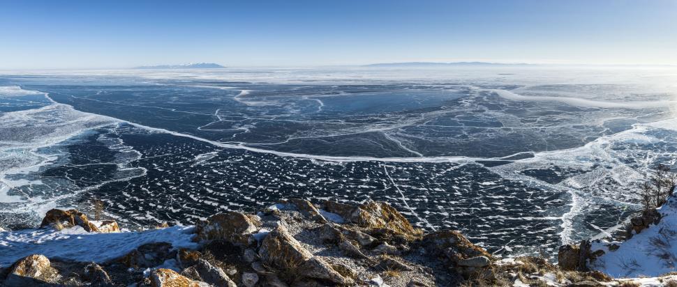 Free Image of Frozen lake with intricate ice patterns stretches wide. 