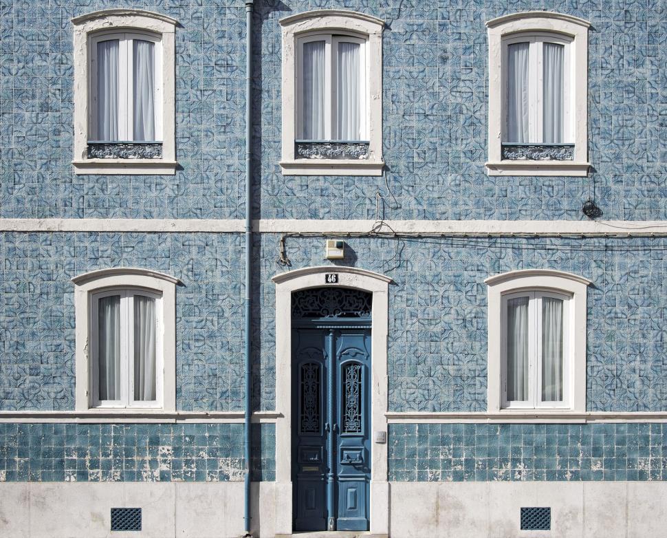 Free Image of Front view of blue patterned building with white windows 