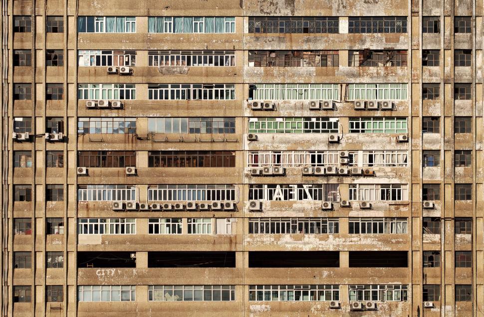 Free Image of Weathered high rise building with many window units 
