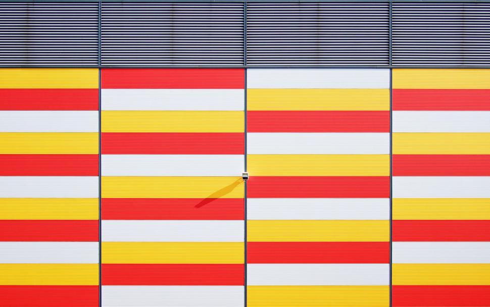 Free Image of Modern facade with yellow, red, and white horizontal lines 