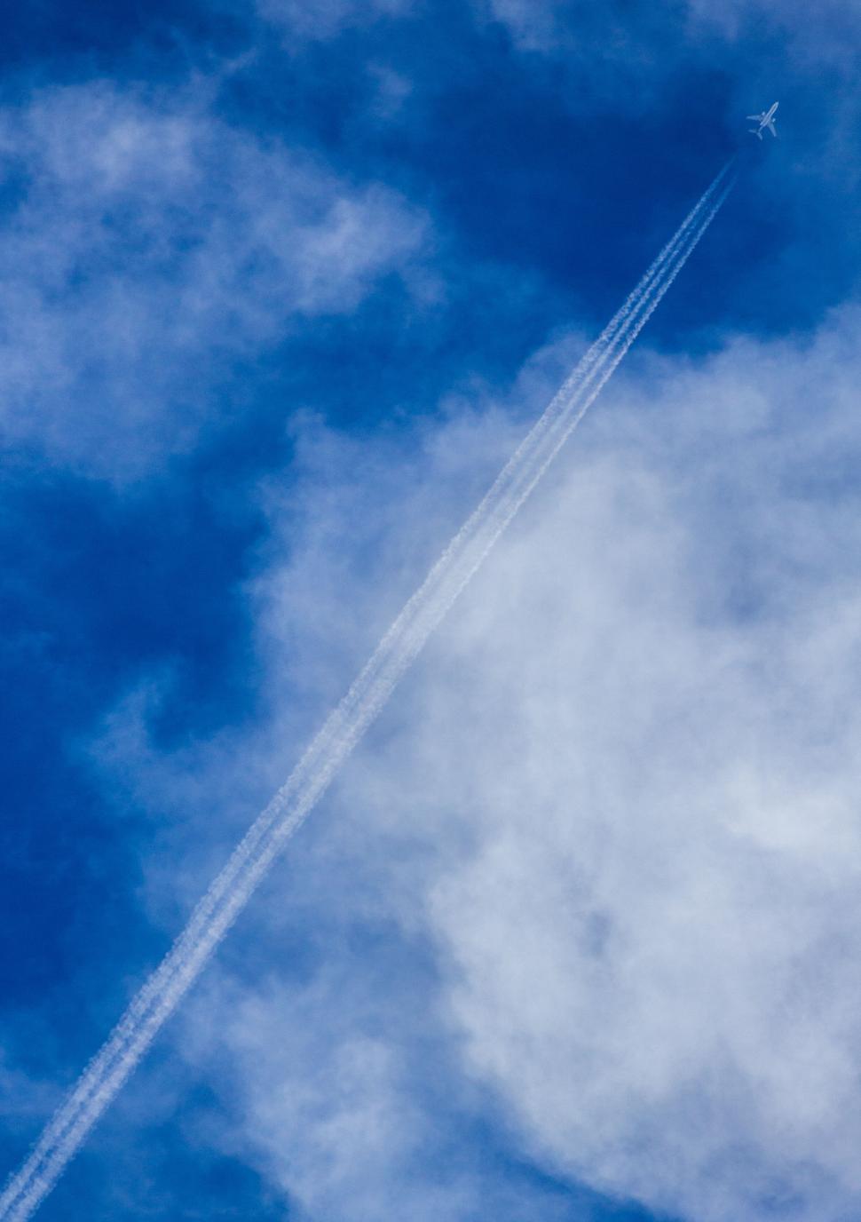 Free Image of Airplane flying high leaving a contrail in blue sky 