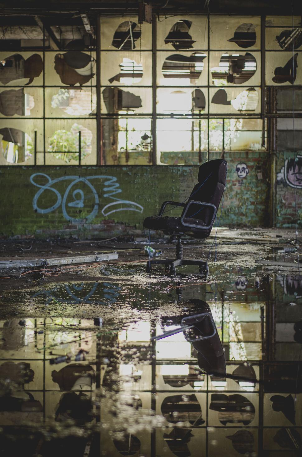 Free Image of Abandoned room with broken windows and discarded chair 