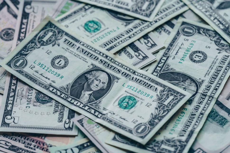 Free Image of One dollar bills scattered creating money background image. 