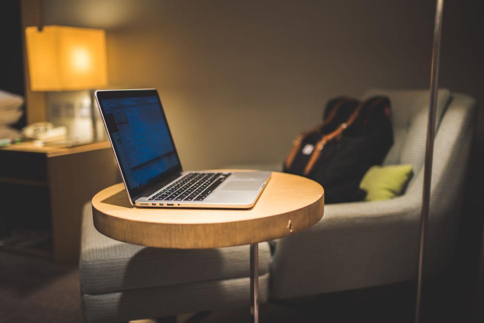 Free Image of Laptop on a small table in a cozy room setup 