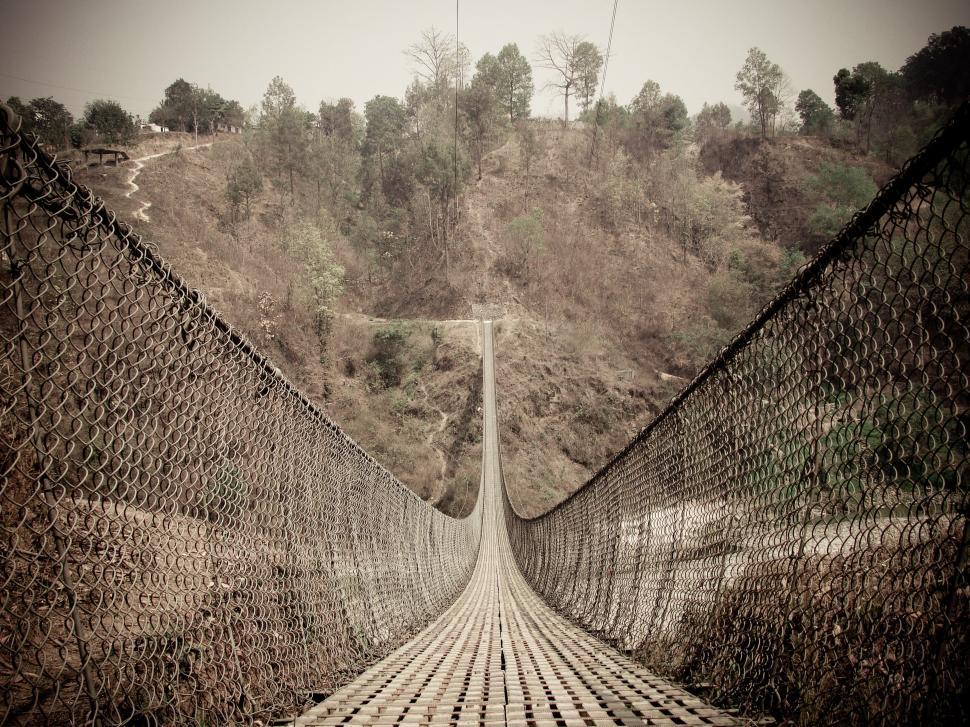 Free Image of Suspension bridge spanning over rugged landscape 