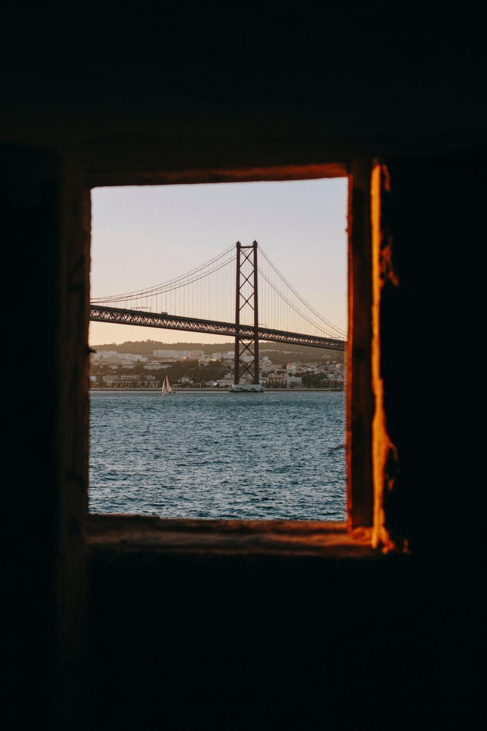 Free Image of Bridge view through window with sunset in background 