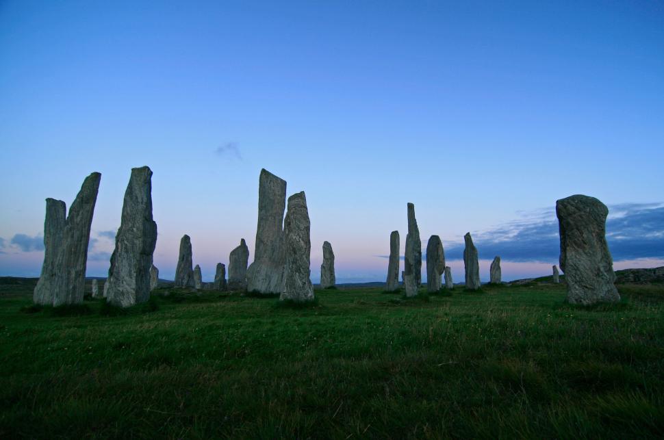 Free Image of Mysterious standing stones at dusk against blue sky. 
