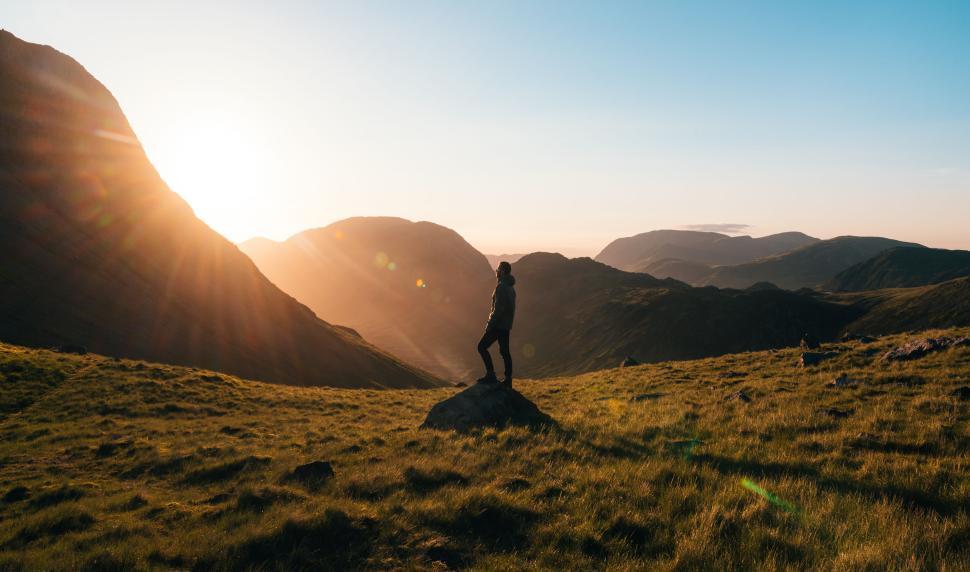 Free Image of Hiker on mountain at sunrise enjoying the panoramic view. 