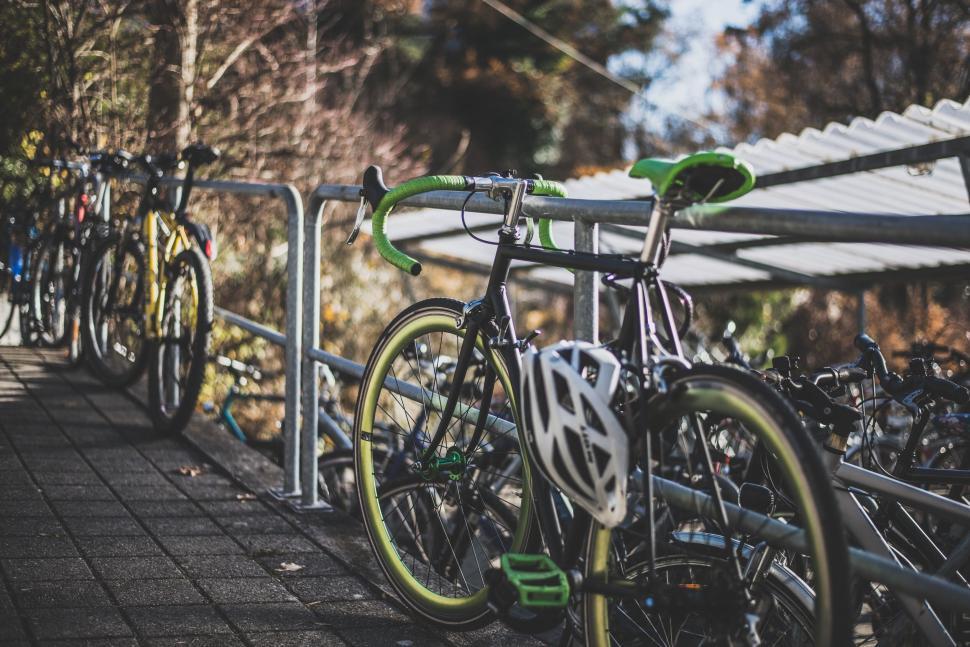 Free Image of Sleek black bicycle parked on a rack in urban setting. 