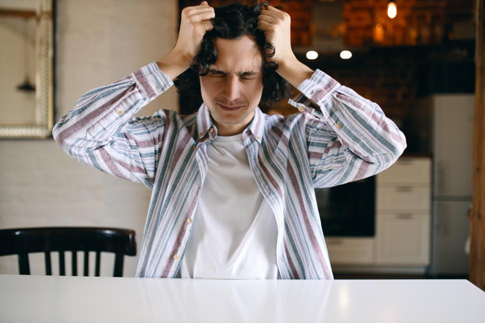 Free Image of Stressful student pulling his hair out being frustrated because he failed exams at college. Desperate unemployed young male having problems, sitting at home, feeling depressed. Stress and depression 