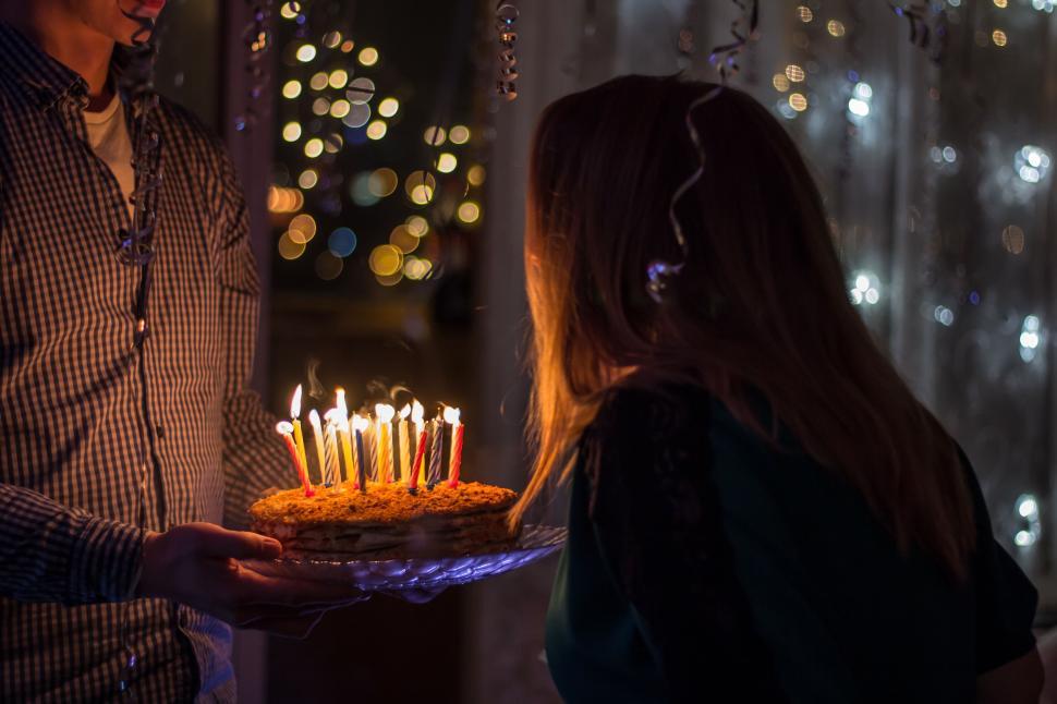 Free Image of Candlelit birthday cake presented by someone 