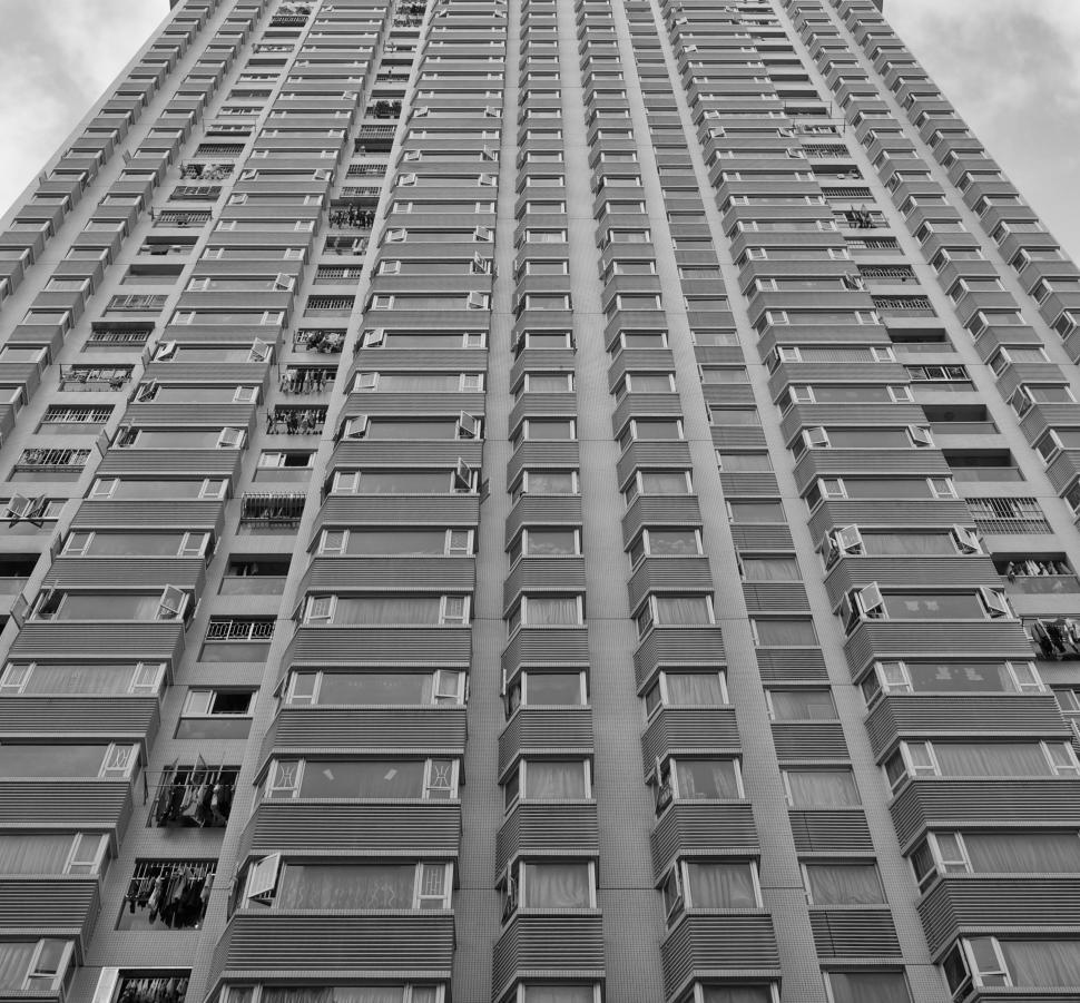 Free Image of Tall gray apartment building viewed from ground perspective. 