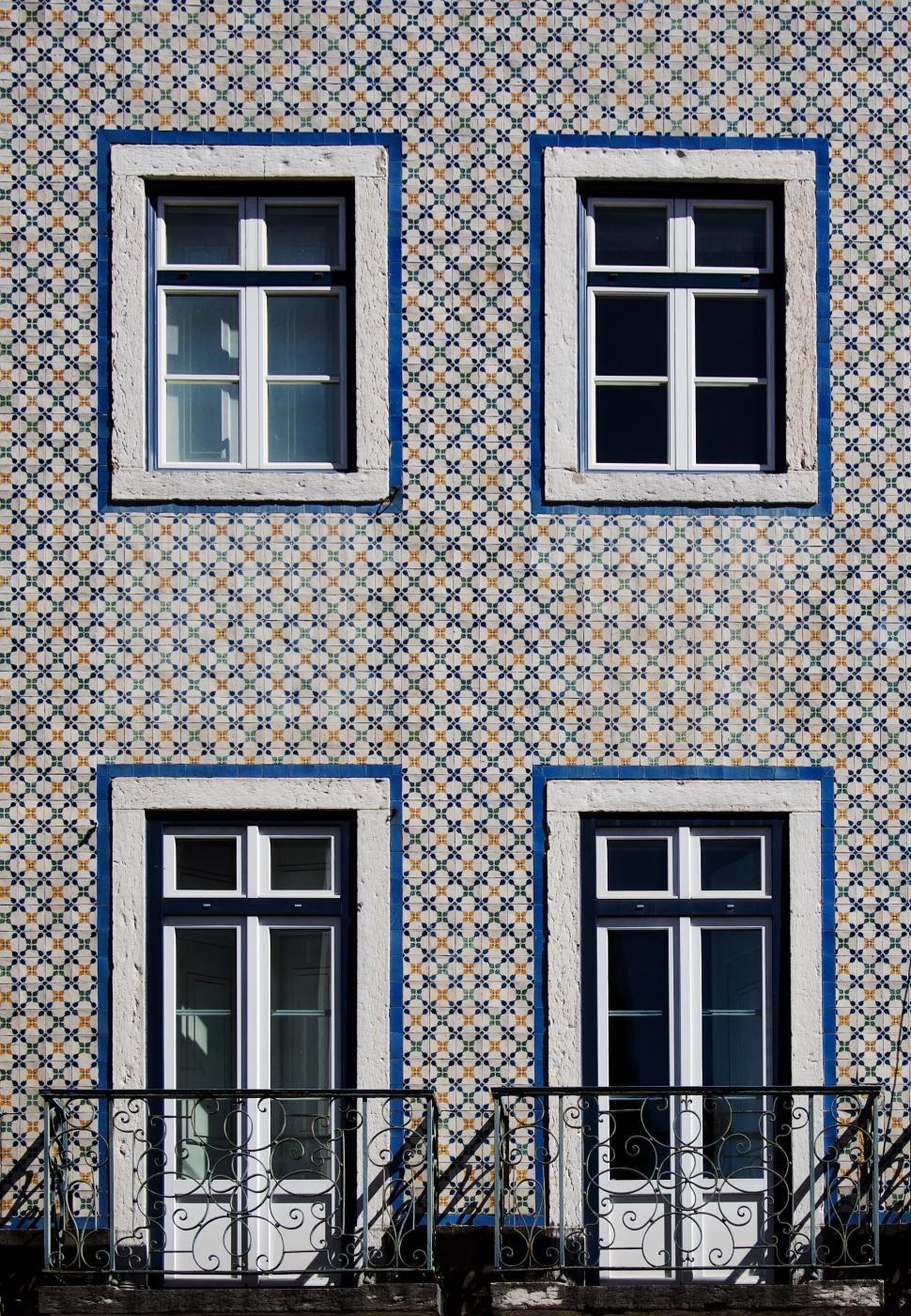 Free Image of Building facade with traditional patterned tiles and windows. 