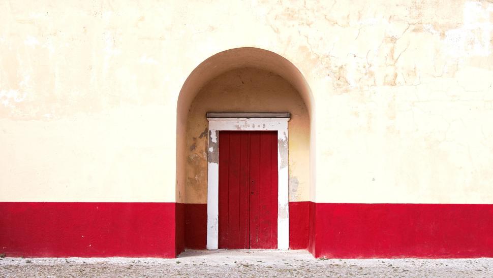 Free Image of Red and white painted door in arched yellow wall 