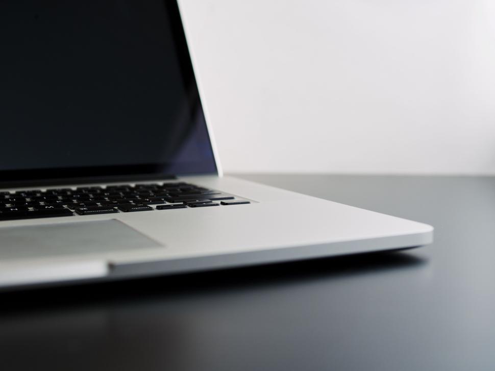 Free Image of Sleek modern laptop resting on minimalist black desk 