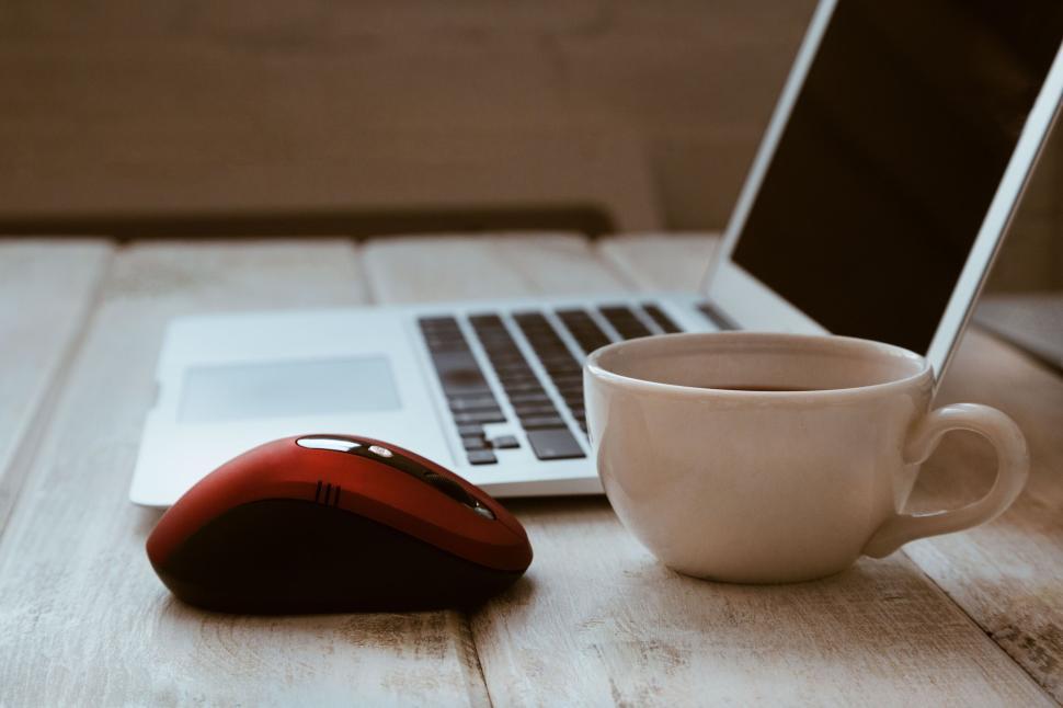 Free Image of Laptop with red mouse and coffee cup on wooden table. 