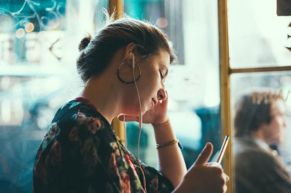 Free Image of Person enjoying coffee shop, listening music on phone. 