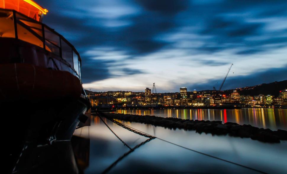 Free Image of City harbor at dusk with reflected lights on the water 