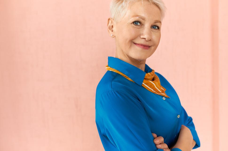 Free Image of Closeup shot of beautiful successful blonde middle aged businesswoman with great experience and skills posing isolated with arms crossed, wearing elegant clothes, her posture expressing confidence 