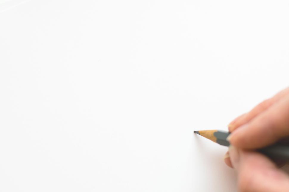 Free Image of Hand writing with pencil on blank white paper 