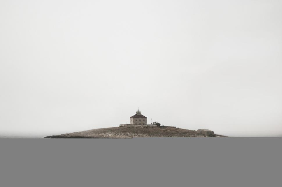 Free Image of Isolated lighthouse on a small island on a misty day 