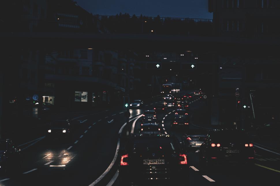 Free Image of City street with cars driving at night under bridges 