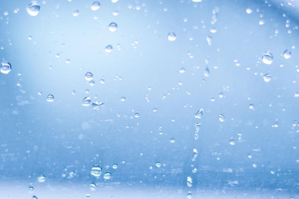 Free Image of Water droplets on a glass surface with bluish backdrop 