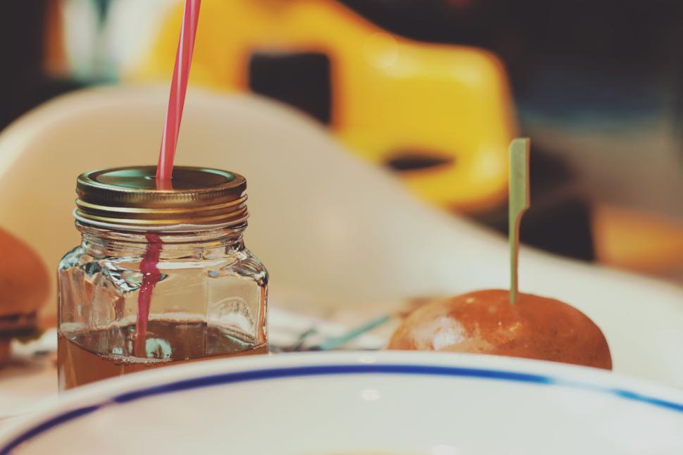 Free Image of Jar with beverage and burger with lid on a table 