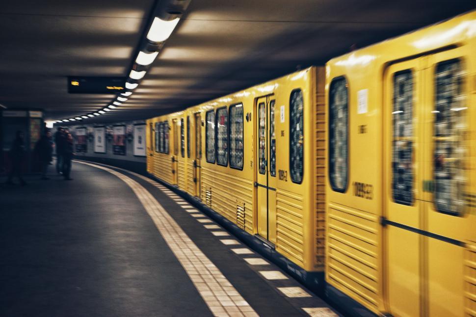 Free Image of Yellow subway train speeding through an underground station 