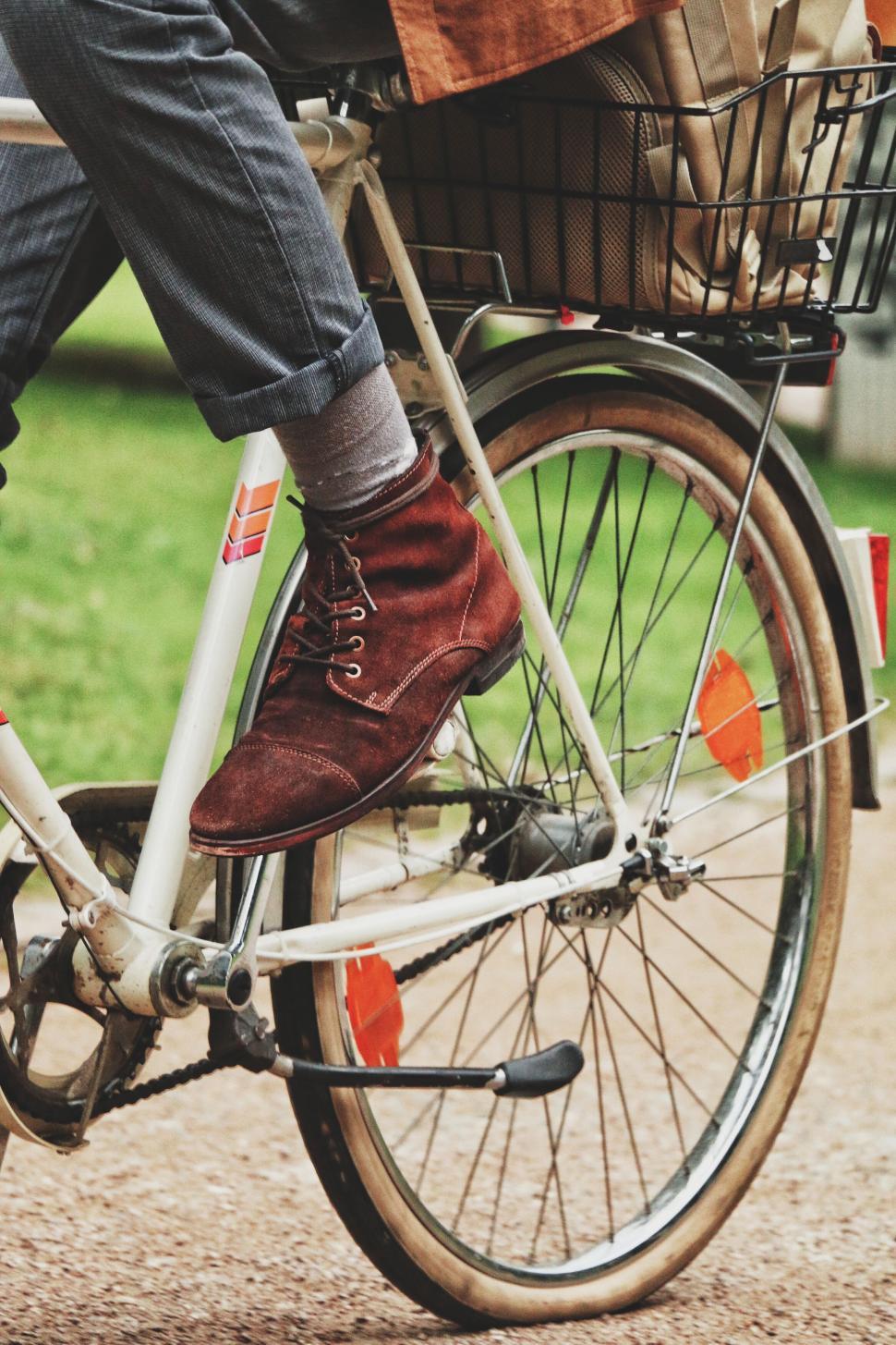 Free Image of Cyclist in red boots riding a bicycle with a rear basket 