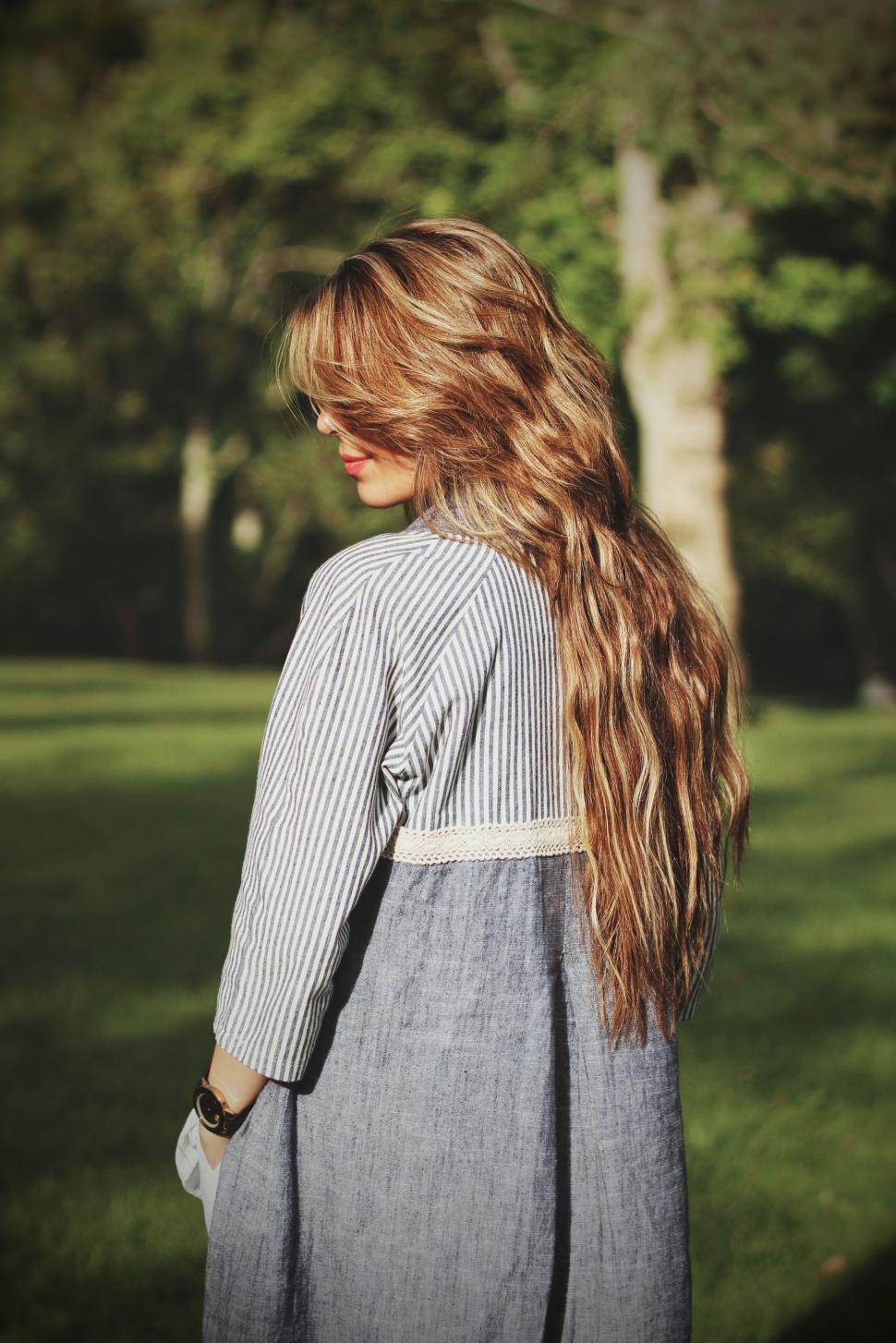 Free Image of Woman with long hair, striped dress, in natural garden. 