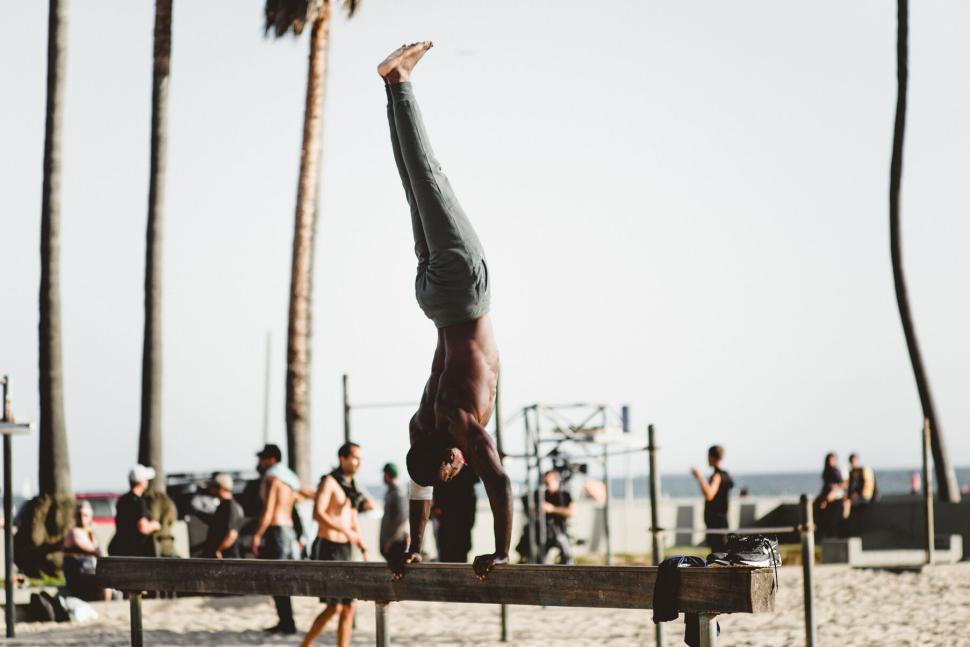 Free Image of Person doing a handstand on a bar at the beach. 