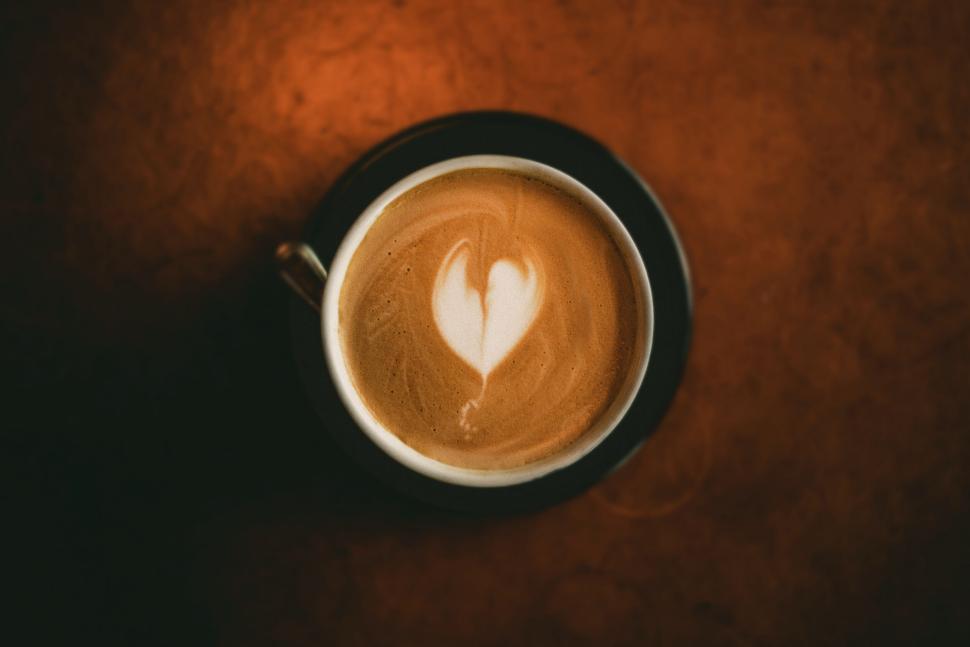 Free Image of Latte art in a cup on a dark brown surface 