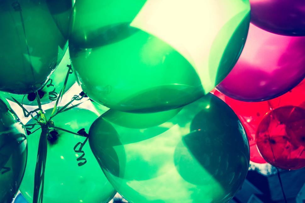 Free Image of Close-up of vibrant green and red balloons in sunlight 
