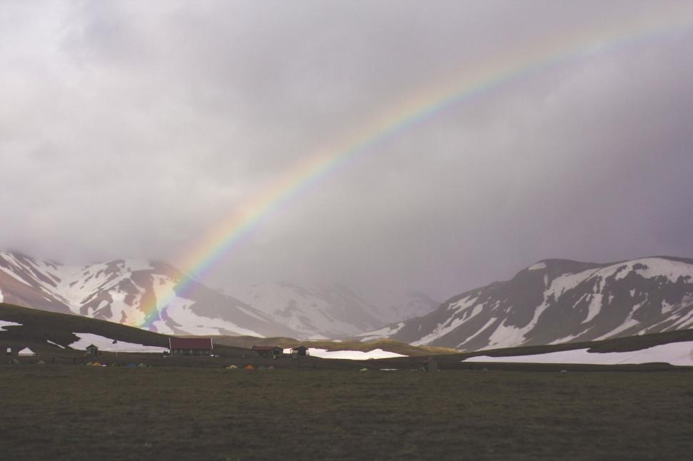 Free Image of Beautiful rainbow over a scenic mountainous landscape 