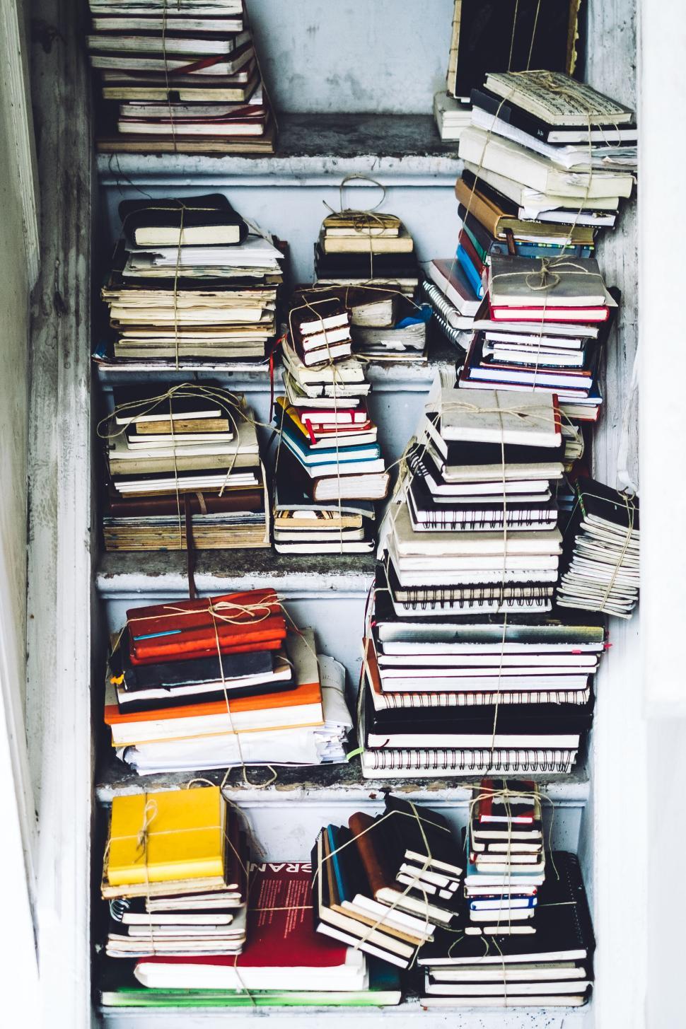 Free Image of Bundles of various notebooks arranged in a small space 