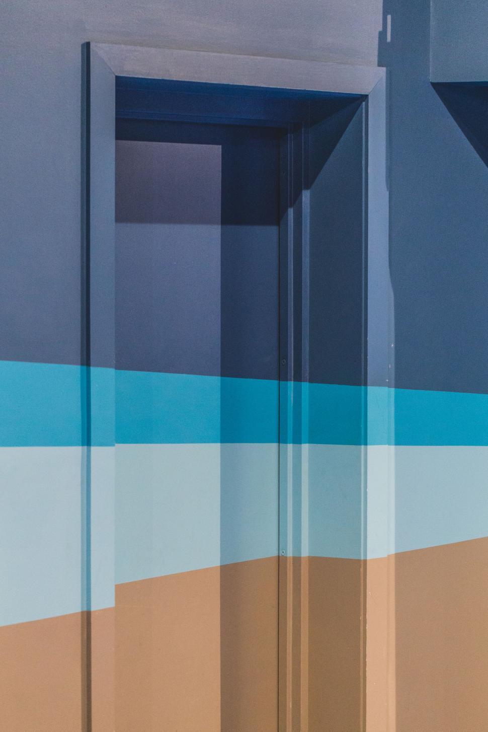 Free Image of Colorful wall with overlapping paints, blue and brown. 