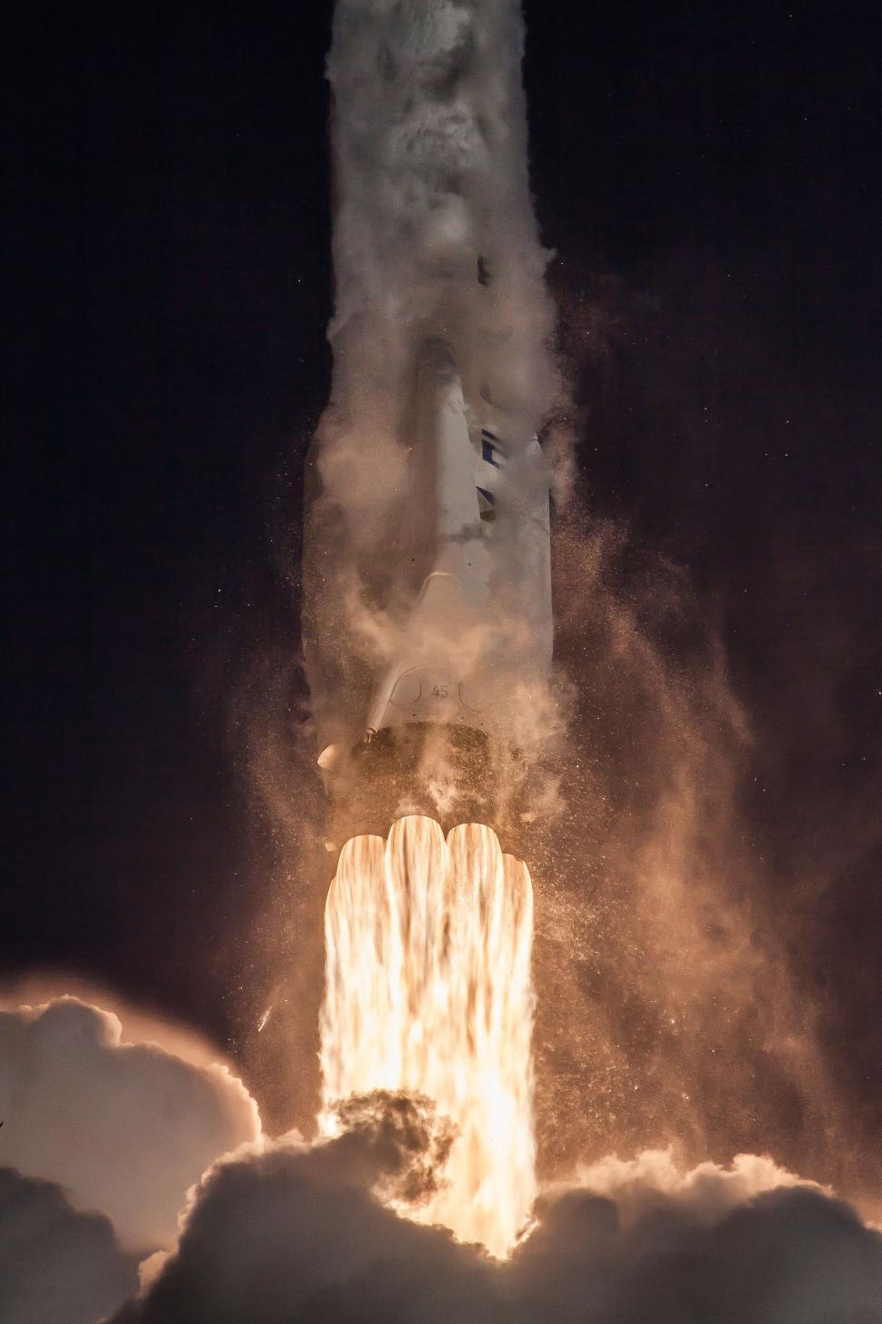 Free Image of Rocket launching into the night sky with ignited engines 