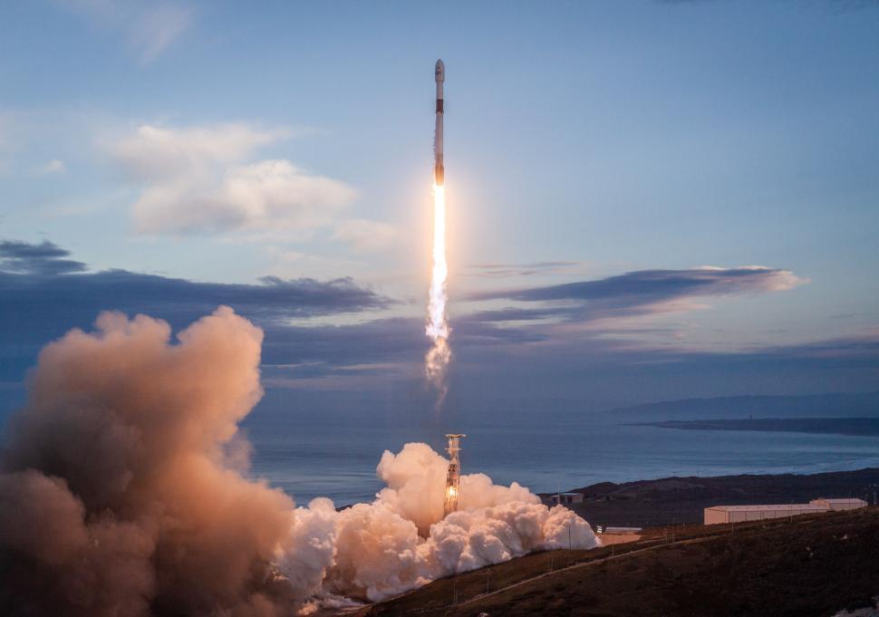 Free Image of Rocket ascends into the sky above the ocean at sunrise 