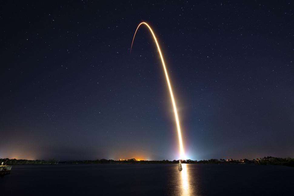 Free Image of Night rocket launch leaving a bright trail in dark sky. 