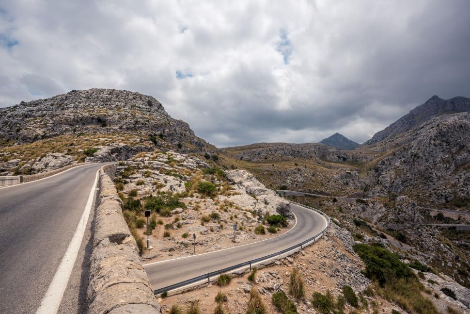 Free Image of Mountain road with sharp turns and rocky terrain. 