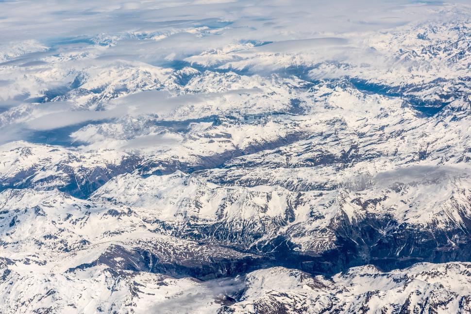 Free Image of Aerial view of snow-covered mountains under clear sky 