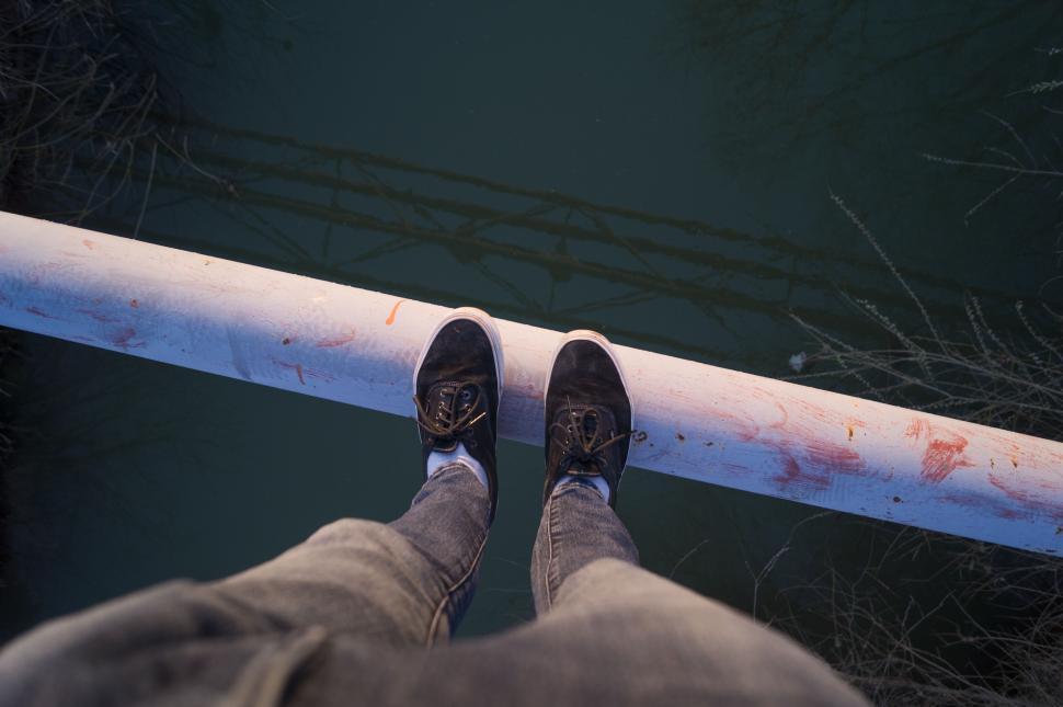 Free Image of Person standing on edge overlooking a vast water body. 