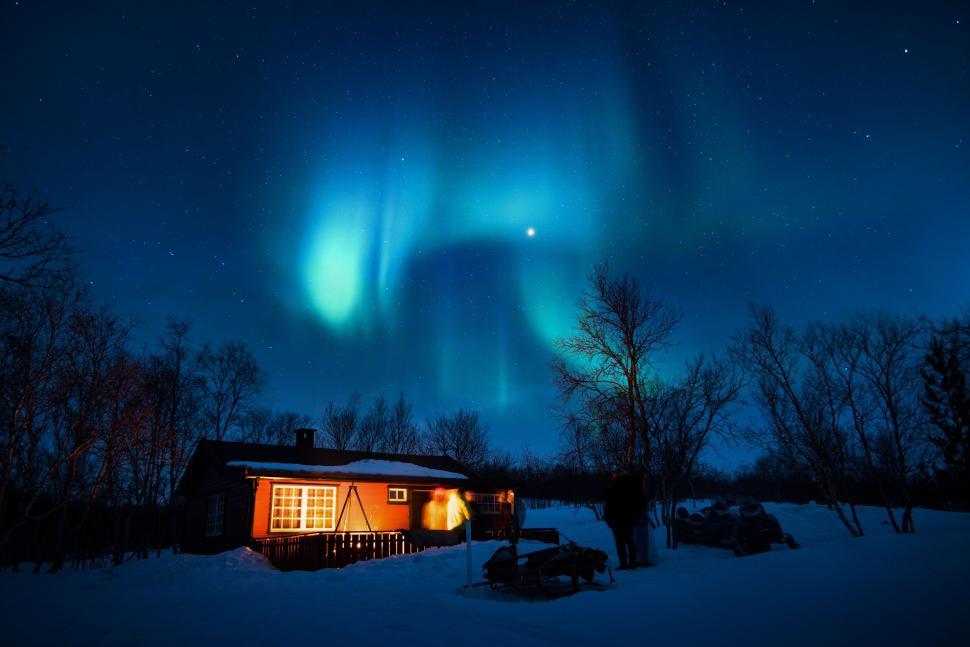 Free Image of Cozy cabin under the northern lights in a winter night. 