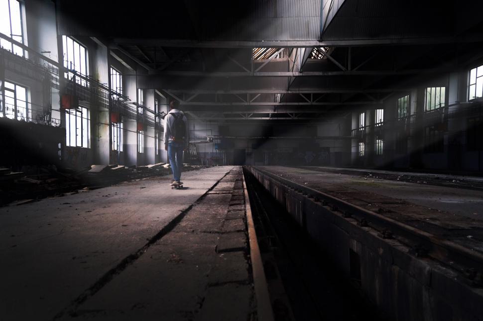 Free Image of Skateboarder exploring abandoned industrial building 