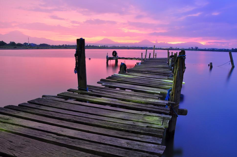 Free Image of Old wooden pier on calm lake during colorful sunset. 